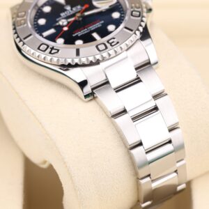 Blue dial watch on wrist with metal strap
